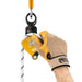 Hand model wearing a glove installing a rope on the Petzl Spin L1D  single pulley with one-way rotation and swivel