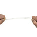 Two hands stretching a thin, white Kong Fast Rubber band against a plain white background.