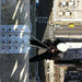 A professional climber uses the SMC Flex Rope Protector on the edge of a building, providing rope protection during a technical descent in an urban setting