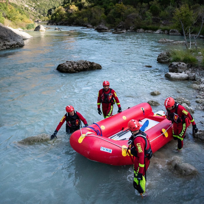 4 rescue responders wading with WRS mega sled in a river 