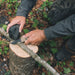 Gear Aid Kotu Coyote Knife being used to cut a thin branch outdoors probably for fire kindling 