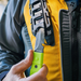 Hand model demonstrating Green Gear Aid Akua River Knife and black sheath storage holder attached to PFD 